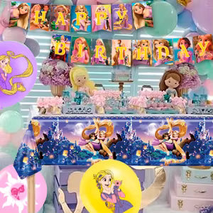 Table d'anniversaire décorée avec gâteau, ballons violets et toile de fond illustrant le royaume de Corona.