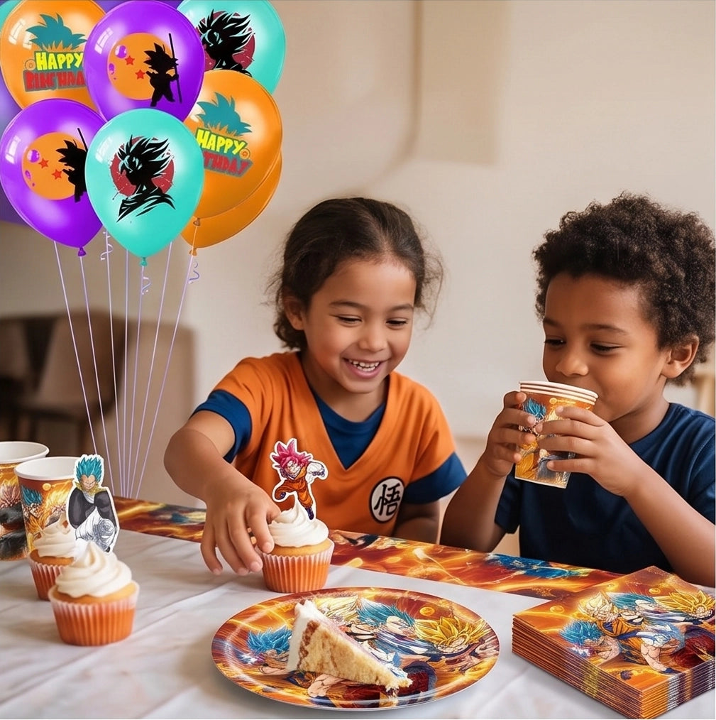 Deux enfants souriants assis à une table d'anniversaire Dragon Ball Z en train de manger des cupcakes avec toppers et de boire dans des gobelets de la saga.