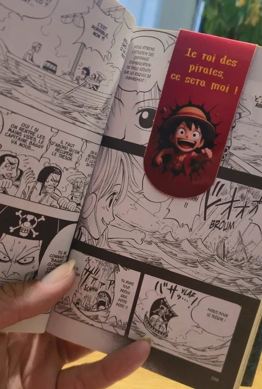 Marque-page magnétique Luffy avec la citation « Le roi des pirates, ce sera moi ! » dans un manga.
