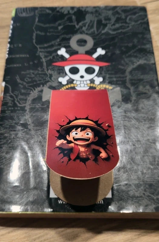 Gros plan sur la fixation magnétique d'un marque-page One Piece trompe-l'œil sur une page de manga.