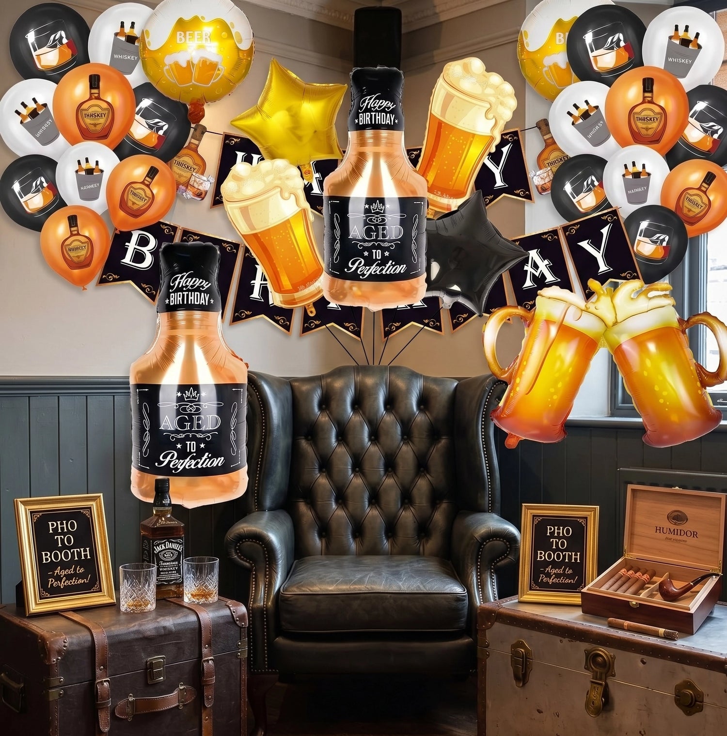 Espace photobooth d'anniversaire avec un fauteuil capitonné en cuir noir, des malles anciennes, une cave à cigares, des pancartes Photo Booth et un décor de ballons géants en forme de bouteilles de whisky et de pintes de bière.